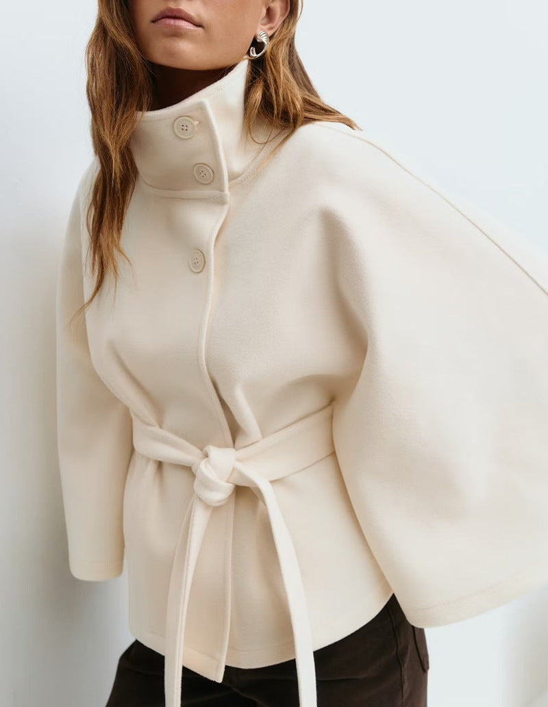 Woman in belted cape coat with high collar