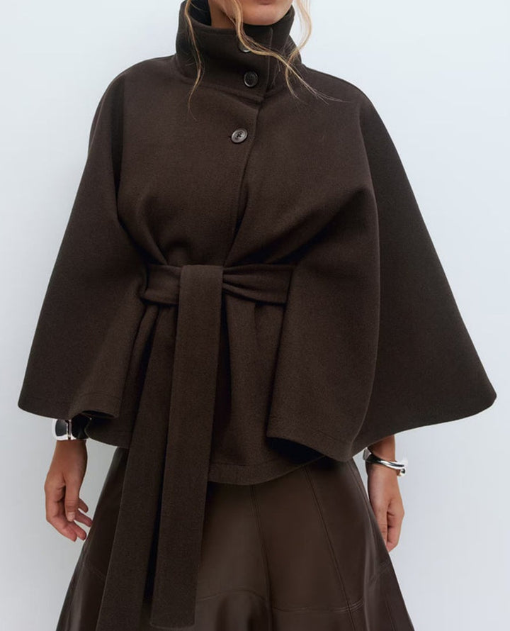 Woman in belted cape coat with high collar