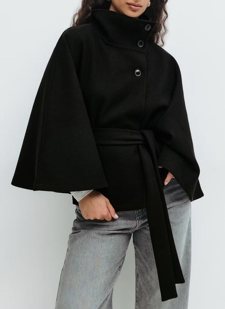 Woman in belted cape coat with high collar